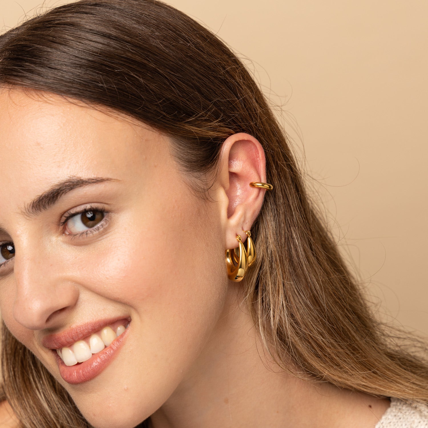 Fashion model stacking Zoi Era Gold Thick Oval Hoop Earrings – chunky anti-tarnish waterproof gold jewellery, versatile for everyday or statement wear.
