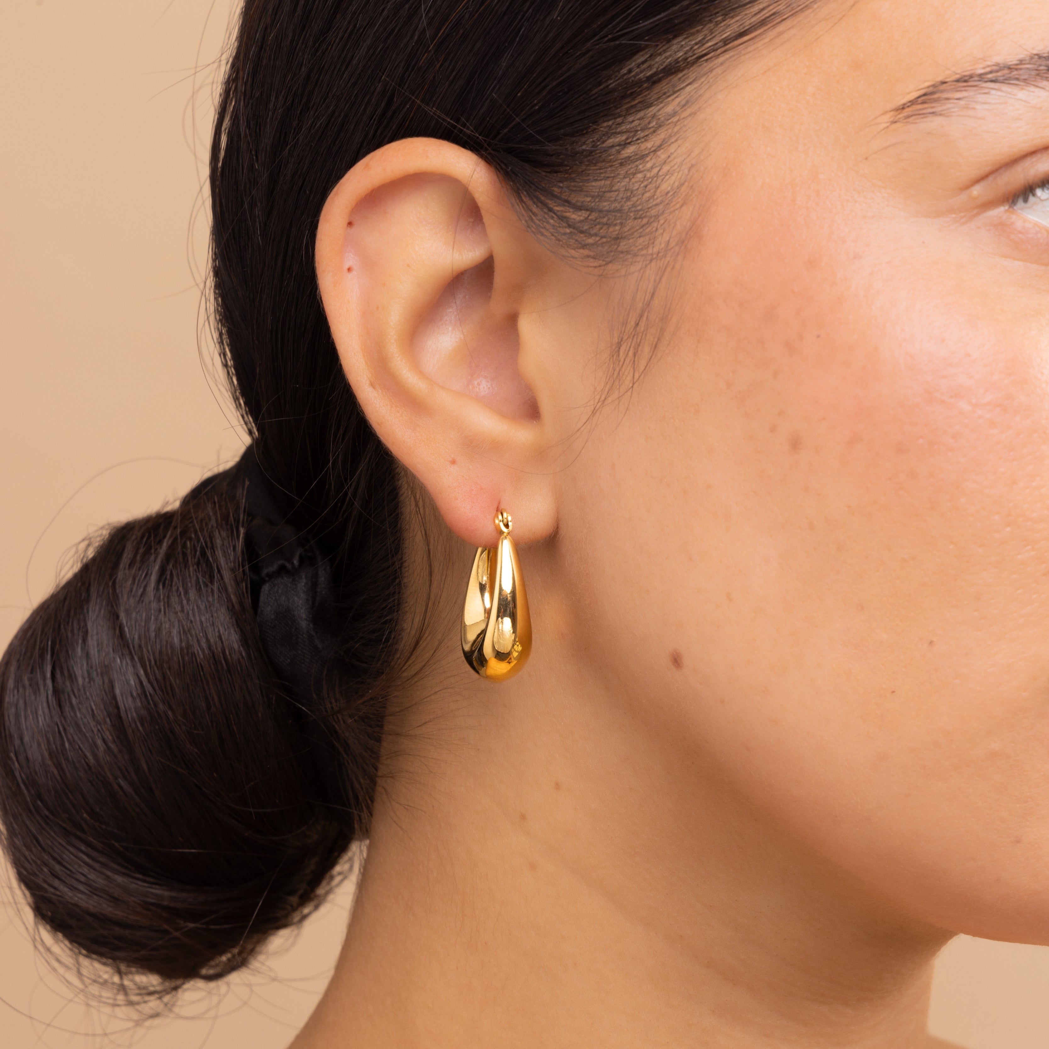 Side profile of model wearing Zoi Era Gold Thick Oval Hoop Earrings – statement oval gold hoops, waterproof stainless steel jewellery, elevated everyday style.