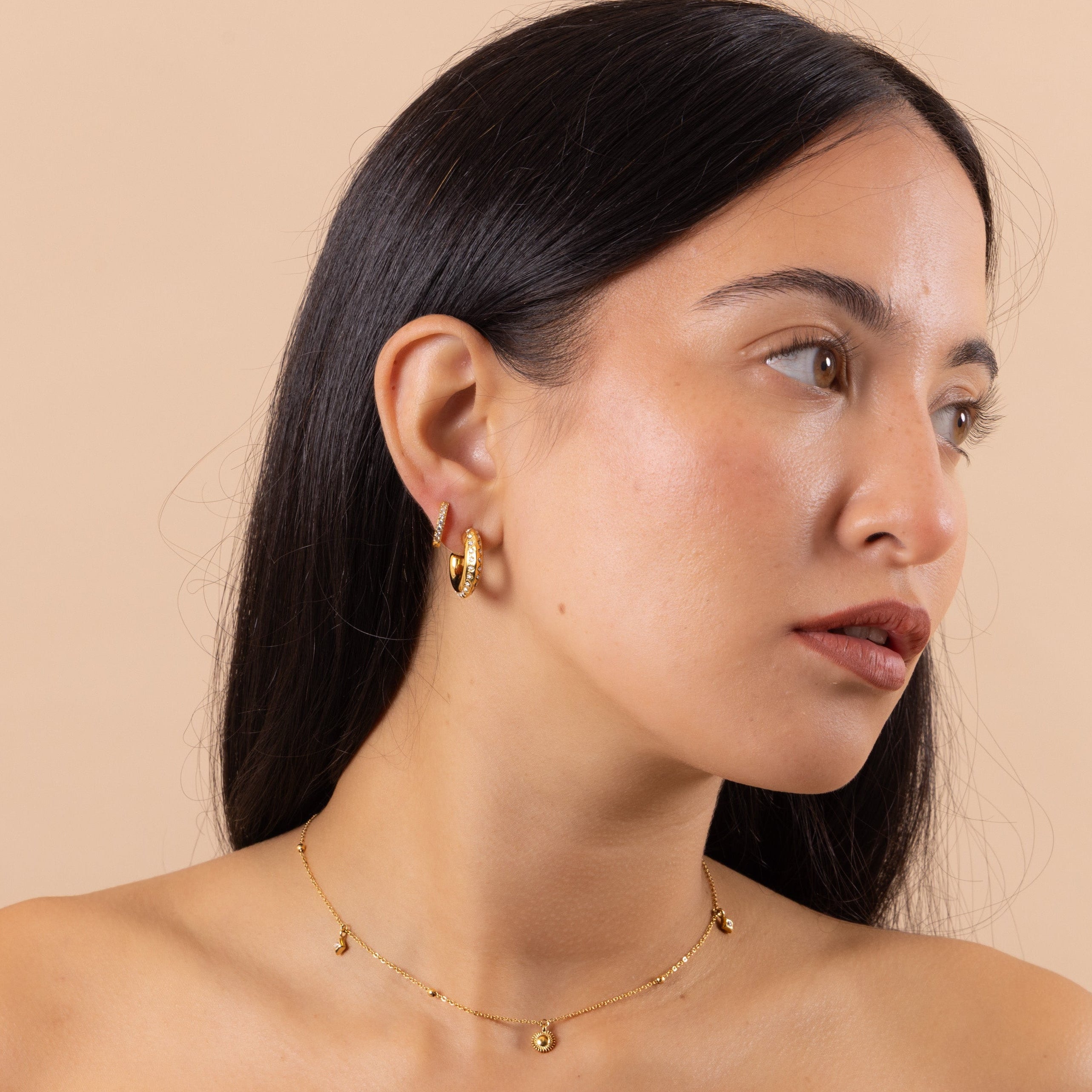 Model wearing gold dainty sun and star necklace with subtle crystal sparkle