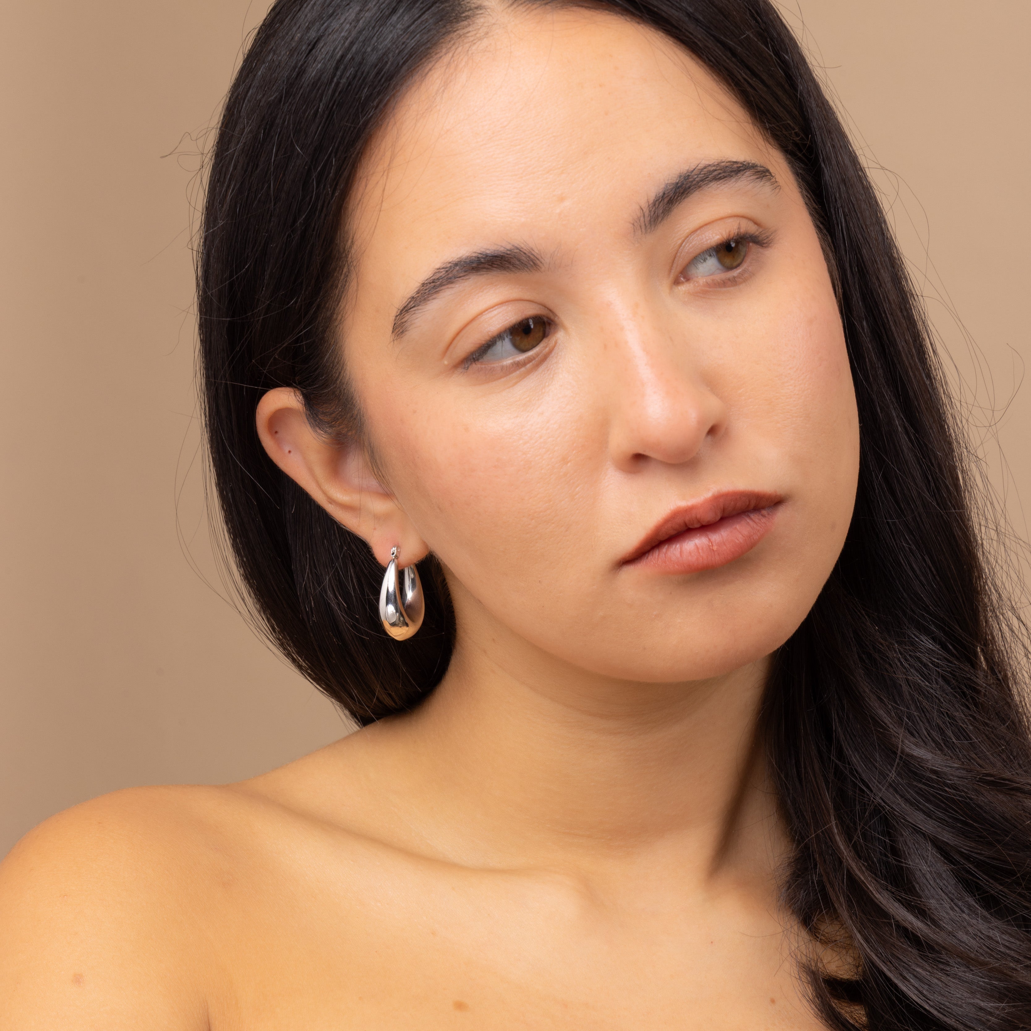 Close-up of Zoi Era bestselling Silver Thick Oval Hoop Earrings – chunky oval silver hoops, waterproof and anti-tarnish, modern jewellery for stacking or solo wear.