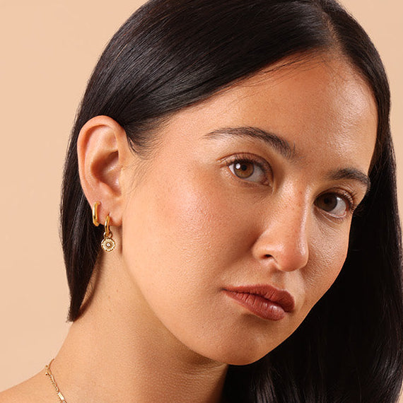 minimalist ear stacking with gold huggie hoop earrings