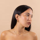 Model wearing gold dainty sun and star necklace with subtle crystal sparkle
