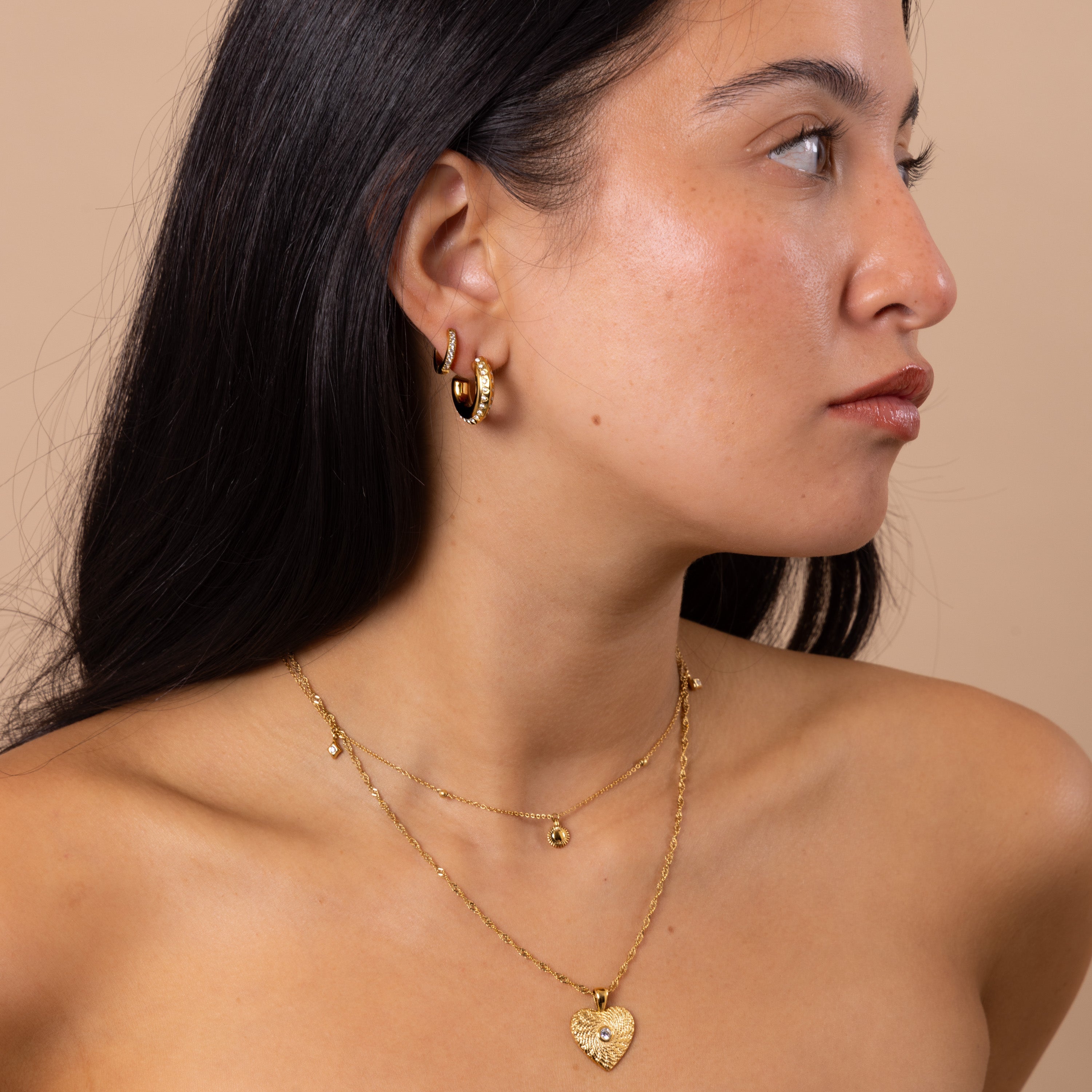Gold charm necklace featuring delicate sun and star pendants, perfect for layering